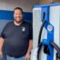 CR Electric owner, Jason Rubin, stands with EV charger to be installed at Greenwood Chevrolet in Austintown
